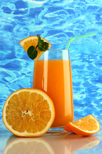 杯橙汁与薄荷和橙色的海面背景