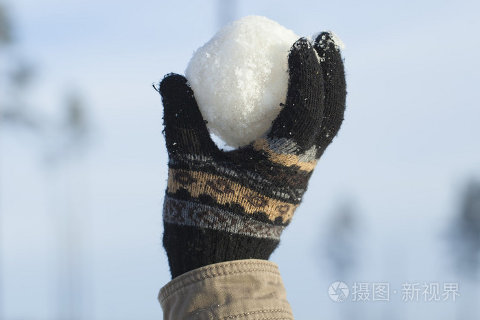 雪球在蓝蓝的天空背景上的手