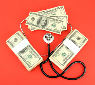 医疗成本的概念 听诊器和红色背景上的美元