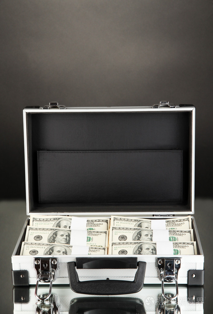 与黑色背景上的 100 美元钞票的手提箱