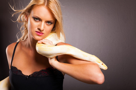 酷时尚女人持 python 在她的肩上