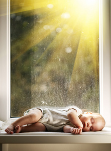 宝宝睡在窗口上的白毛毯上