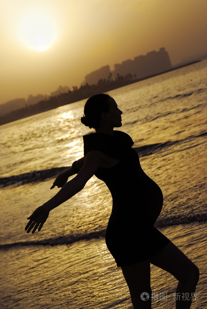 快乐美丽的孕妇在泳装放松在海滩上健康和休息的概念