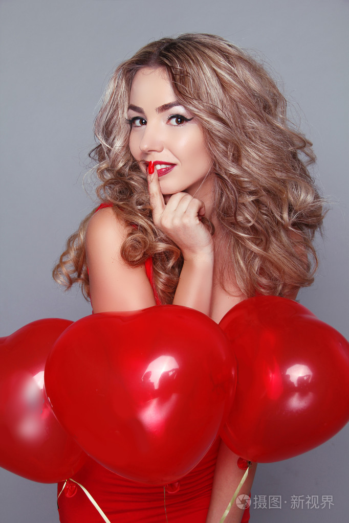 美丽的年轻女子，与红色心形气球