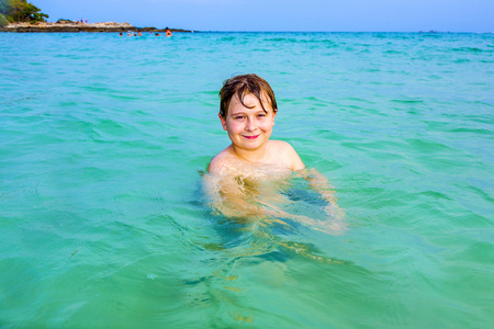 英俊的男孩在海洋中有乐趣