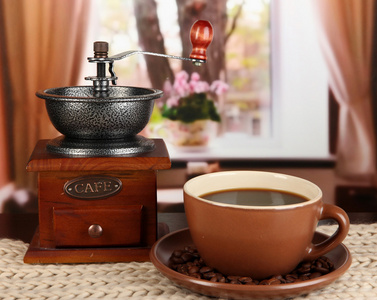 杯咖啡与围巾和在房间里桌上的咖啡磨