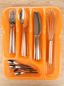 橙色塑料餐具托盘与木桌子上签餐具