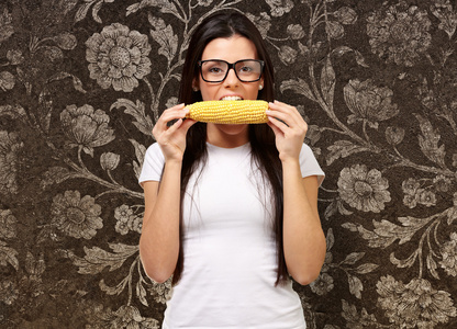年轻的女孩吃玉米