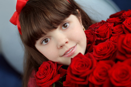 有吸引力的年轻女孩用红玫瑰花束鲜花的肖像