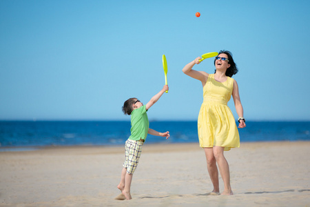 年轻的母亲和儿子在海滩上玩