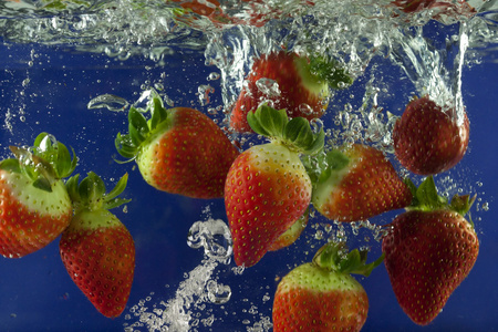游泳入水草莓溅入水的气泡蓝色背景照片