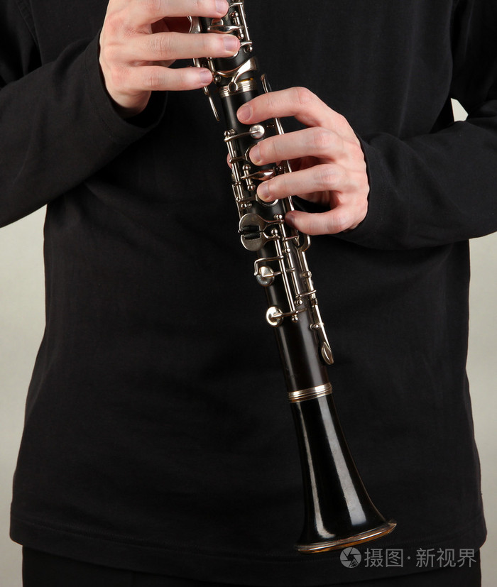 灰色背景上单簧管演奏的音乐家