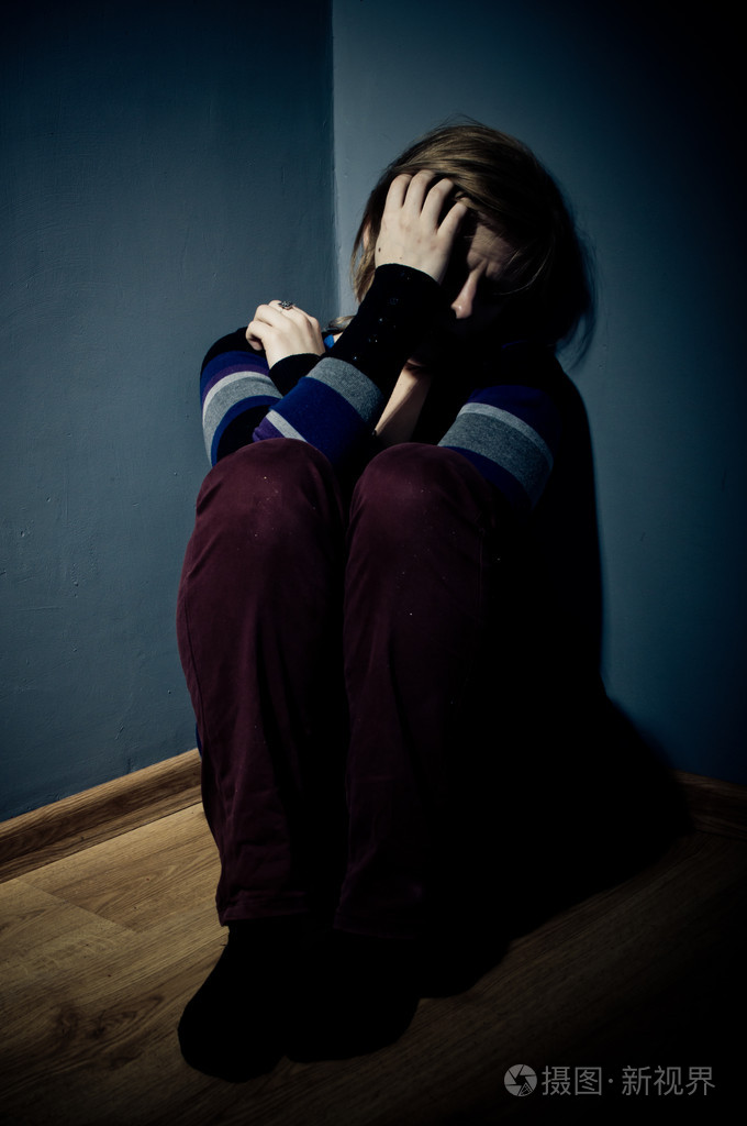 伤心女人独自坐在一个空房间