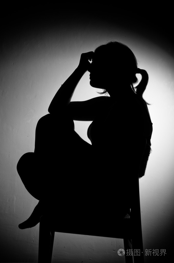 伤心女人独自坐在一个空的房间黑色和白色