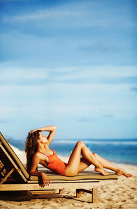 年轻美丽的女人在海滩上休息