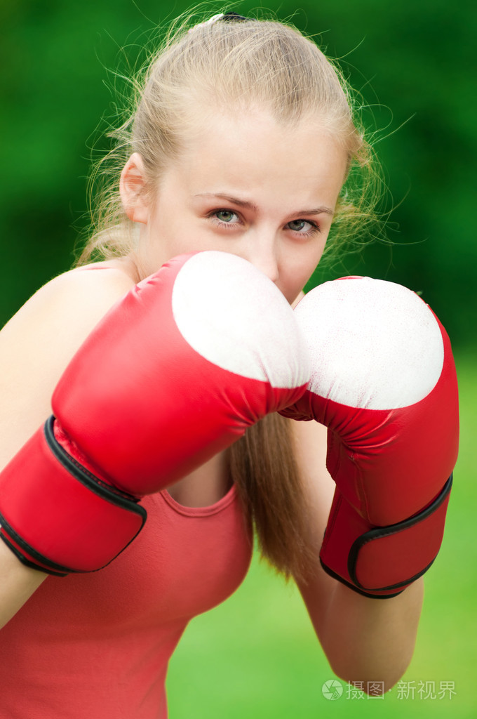 年轻拳击手女人在绿色公园