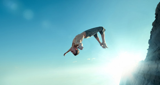 兴奋的年轻人在空气中跳跃背景是蓝天的滑雪运动员在空中跳跃冬季运动