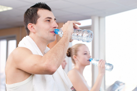 男人和女人在健身房运动后的饮水