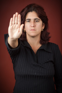 她的手的西班牙裔女人延长信号停止