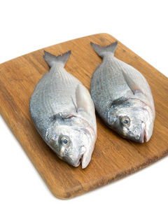 多拉多在白色背景上的切菜板上的鱼
