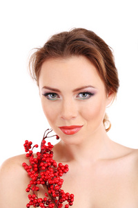 美丽的年轻女子用明亮的化妆品，举行红色浆果，孤立在白色的分支