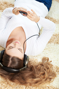 女人躺在地毯上和听音乐