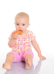 甜蜜小宝宝吃胡萝卜坐在白色地板上
