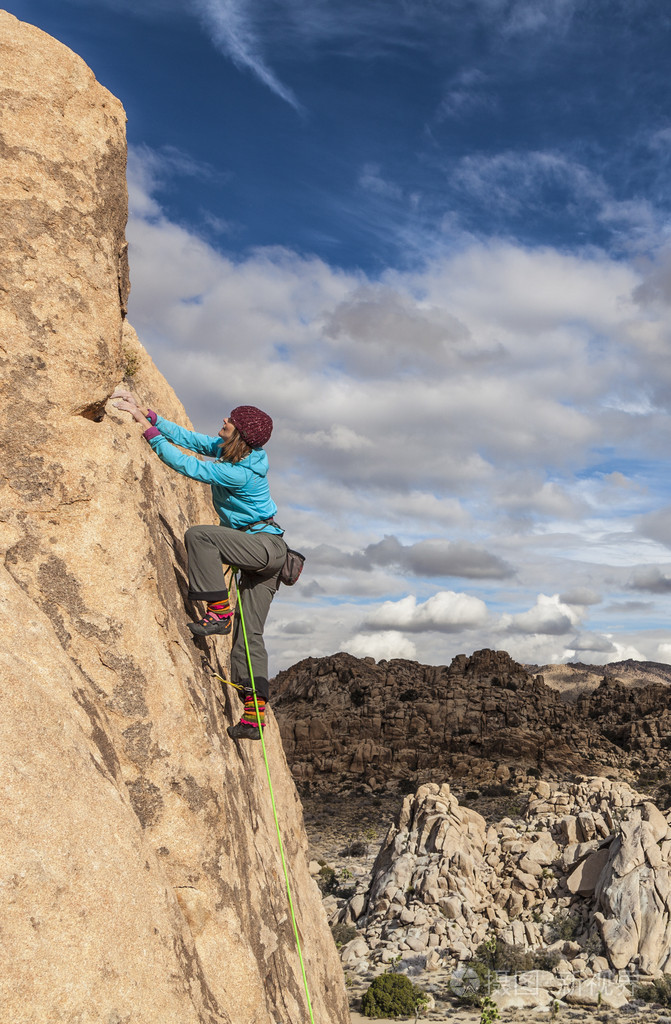 握住岩石的女性登山者