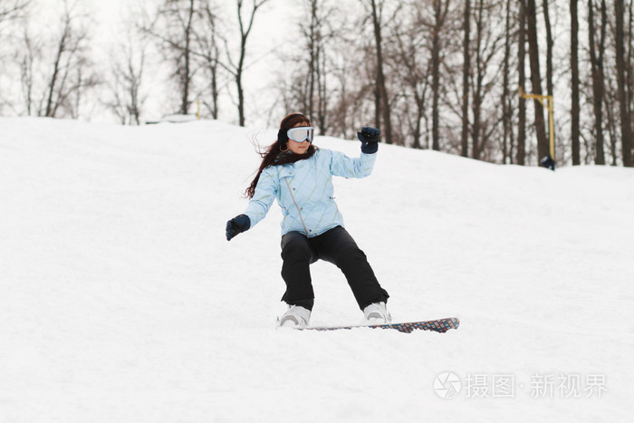 年轻的女子在单板滑雪