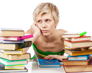年轻的学生有很多书籍为期末考试的女人