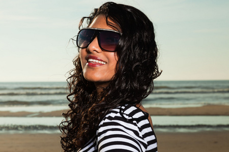 太阳镜夏季海滩上的漂亮印度女孩