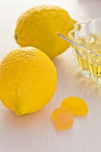 两个黄色的柠檬和蜂蜜玻璃杯子
