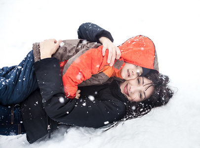 母亲和孩子玩在雪中