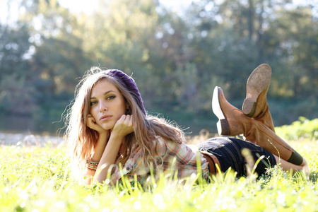 美丽的年轻女子躺在草地上