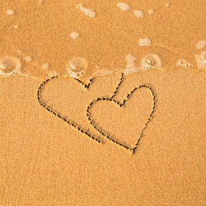 海在情人节海滩上的两颗心的形状。软海中的波浪