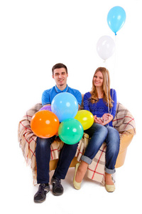 朋友们坐在沙发上，把气球隔离开来