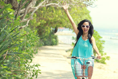 在海滩上骑自行车玩得很开心的女人
