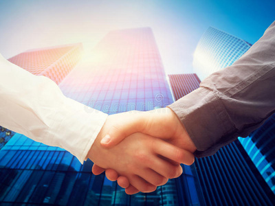 商务握手,摩天大楼背景.交易成功合作照片