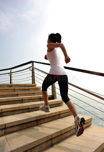 健康的生活方式女人在石头楼梯上跑步