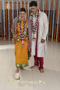 印度印度教新娘在婚礼后用脚推装满大米的锅进入新郎家。