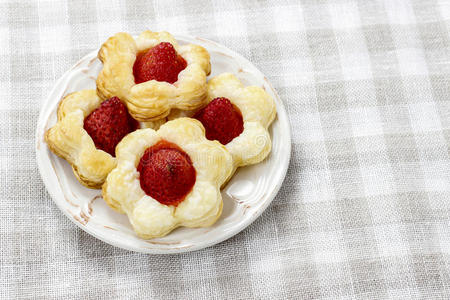 用草莓填充花朵形状的酥皮饼干。