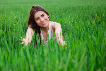 年轻女子在清新的绿色fi中放松和微笑