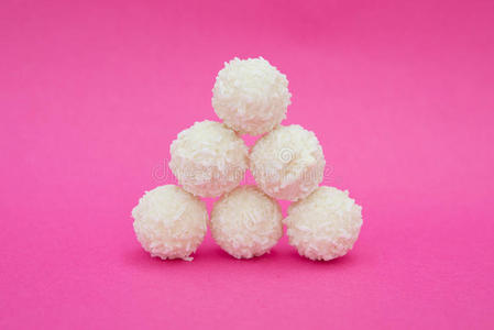粉红色背景的白色椰子糖。
