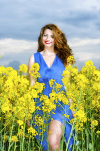 黄色田野里穿着蓝色衣服的年轻女子