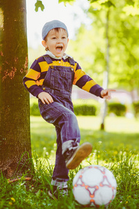 快乐的男孩在公园里玩足球