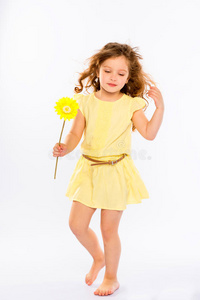 一个穿着黄色连衣裙的顽皮小女孩