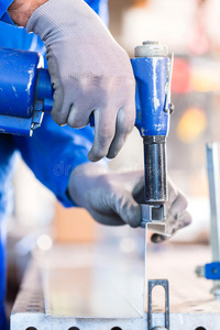 工匠在车间铆接金属照片