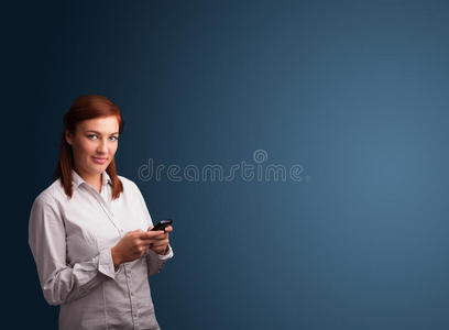 一个年轻的女人站着用手机打字
