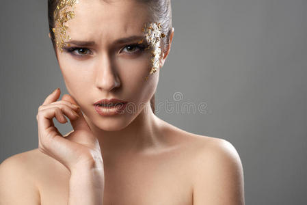 美丽的女孩用金色的化妆艺术