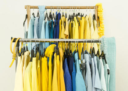 商店衣架上颜色协调的衣服的特写镜头。